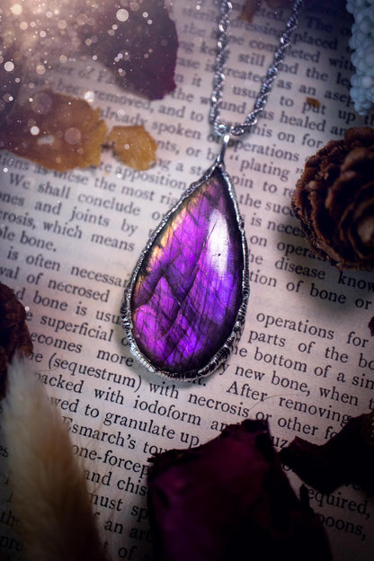 A beautiful, one of a kind, purple, green and grey multi-flash Labradorite crystal pendant necklace. This pendant has been handmade using the soft solder method, also known as the tiffany technique used to create stained glass windows. Featuring the most stunning and natural Labradorite crystal which is full of purple and green hues. The  pendant is suitable for gifting to any jewellery or crystal lover, or to simply add to your own collection. One of a kind jewellery, gothic and witchy gifts