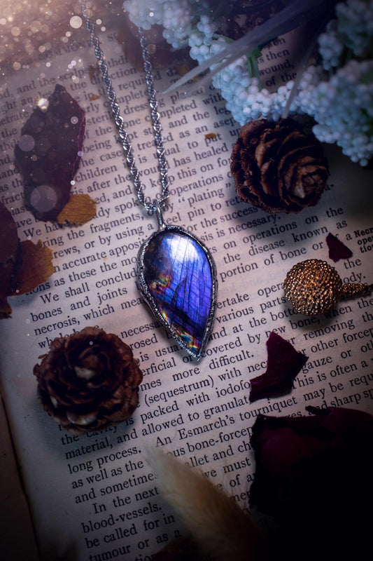 A beautiful, one of a kind, purple, green and grey multi-flash Labradorite crystal pendant necklace. This pendant has been handmade using the soft solder method, also known as the tiffany technique used to create stained glass windows. Featuring the most stunning and natural Labradorite crystal which is full of purple and green hues. The  pendant is suitable for gifting to any jewellery or crystal lover, or to simply add to your own collection. One of a kind jewellery, gothic and witchy gifts