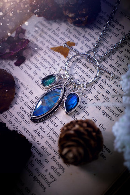 Beautiful and handmade, multi crystal charm pendant necklace. This stunning pendant necklace features a teal kyanite, a rainbow moonstone, and a purple labradorite crystal which hangs from a hammered toggle clasp. Made from a mix of fine and sterling silver, this necklace is very unique with all the beautiful crystals one could need! All crystals are natural and full of flash and vibrant colour. Ideal for any crystal or jewellery lover. Hippy, gothic and witchy jewellery.