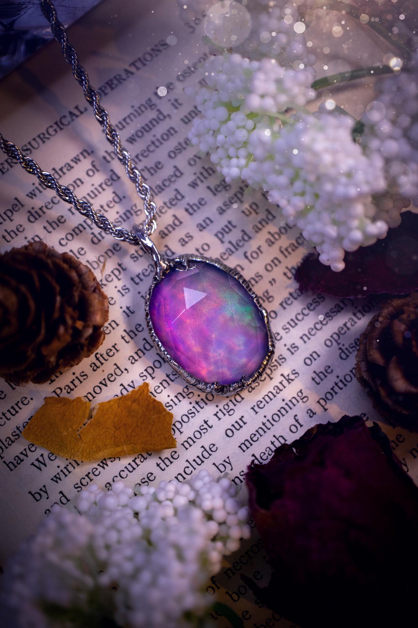 A beautiful, one of a kind, aurora opal pendant necklace. This little statement necklace is handmade using the tiffany technique, also known as soft soldering. Featuring the most stunning, and sparkly aurora opal which is full of pinks, greens and blues just like the northern lights. Aurora opals are man made opals that look similar to natural ones, they have a layer of rose quartz on top to give extra shine. The ideal gift for any crystal or jewellery lover. Gothic and witchy jewellery