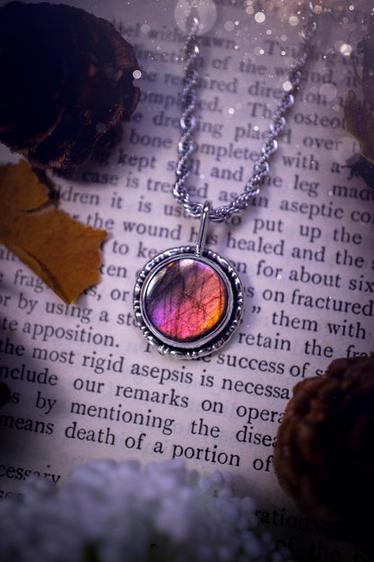 Dainty but beautiful, handcrafted, natural pink, purple, and silver labradorite spectrolite pendant necklace. This beautiful pendant has been handmade using recycled fine and sterling silver. Featuring a round labradorite that is full of natural pinks, purples and silver hues. Around the crystal is a smooth inner bezel with gallery wire around as the outer bezel. This is the ideal piece of jewellery for a loved one or to treat yourself. Suitable for crystal and jewellery lovers. Gothic vibes.