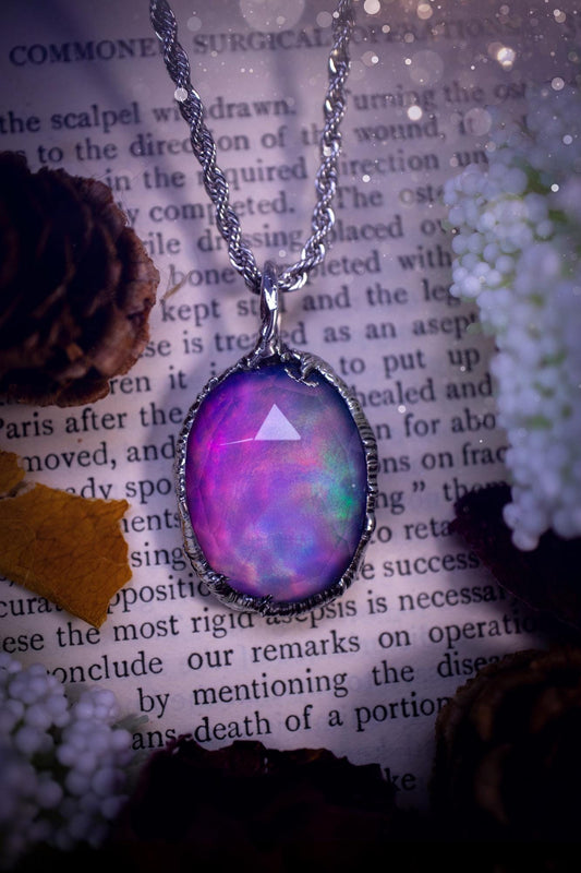 A beautiful, one of a kind, aurora opal pendant necklace. This little statement necklace is handmade using the tiffany technique, also known as soft soldering. Featuring the most stunning, and sparkly aurora opal which is full of pinks, greens and blues just like the northern lights. Aurora opals are man made opals that look similar to natural ones, they have a layer of rose quartz on top to give extra shine. The ideal gift for any crystal or jewellery lover. Gothic and witchy jewellery