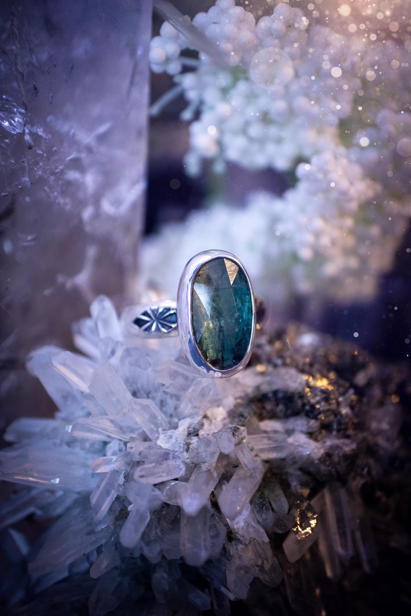 Beautiful and handcrafted, natural teal green kyanite crystal, staking ring. This stunning ring has been hand made using fine and sterling silver. It features a beautiful and natural teal green kyanite crystal that has rainbows and flash, such a gorgeous colour. The ring shank on this ring has been stamped with a gothic pattern to give it a one of a kind vibe. Ideal gift for that special person in your life, or for any crystal and jewellery lover. Hippy, witchy and gothic jewellery for the soul.