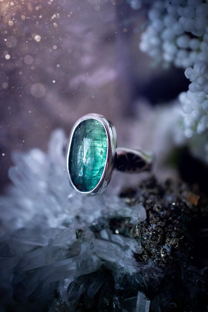 Beautiful and handcrafted, natural teal green kyanite crystal, staking ring. This stunning ring has been hand made using fine and sterling silver. It features a beautiful and natural teal green kyanite crystal that has rainbows and flash, such a gorgeous colour. The ring shank on this ring has been stamped with a gothic pattern to give it a one of a kind vibe. Ideal gift for that special person in your life, or for any crystal and jewellery lover. Hippy, witchy and gothic jewellery for the soul.
