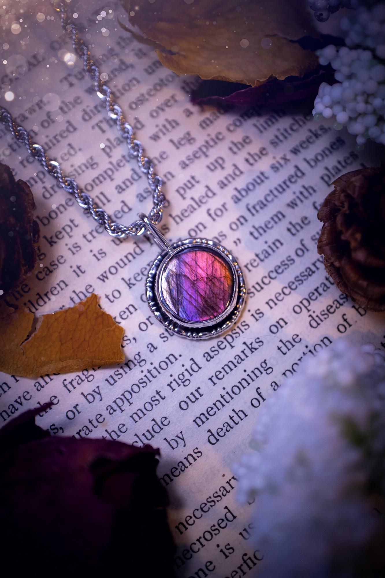 Dainty but beautiful, handcrafted, natural pink, purple, and silver labradorite spectrolite pendant necklace. This beautiful pendant has been handmade using recycled fine and sterling silver. Featuring a round labradorite that is full of natural pinks, purples and silver hues. Around the crystal is a smooth inner bezel with gallery wire around as the outer bezel. This is the ideal piece of jewellery for a loved one or to treat yourself. Suitable for crystal and jewellery lovers. Gothic vibes.