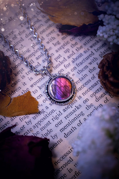 Dainty but beautiful, handcrafted, natural pink, purple, and silver labradorite spectrolite pendant necklace. This beautiful pendant has been handmade using recycled fine and sterling silver. Featuring a round labradorite that is full of natural pinks, purples and silver hues. Around the crystal is a smooth inner bezel with gallery wire around as the outer bezel. This is the ideal piece of jewellery for a loved one or to treat yourself. Suitable for crystal and jewellery lovers. Gothic vibes.