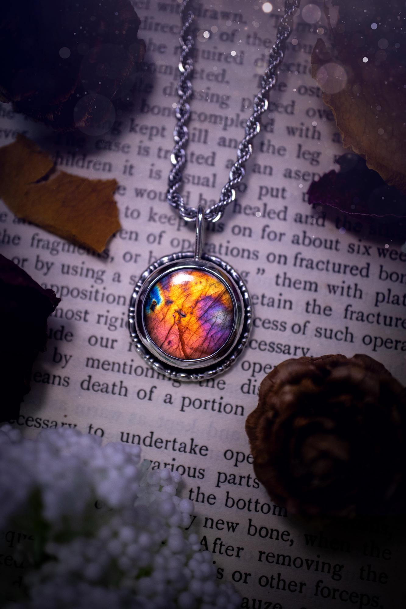 Beautiful and handcrafted, natural rainbow, pink, purple, and orange labradorite spectrolite pendant necklace. This beautiful pendant has been handmade using recycled fine and sterling silver. Featuring a round labradorite that is full of natural pinks, purples and orange hues. Around the crystal is a smooth inner bezel with gallery wire around as the outer bezel. This is the ideal piece of jewellery for a loved one or to treat yourself. Suitable for crystal and jewellery lovers. Gothic vibes.