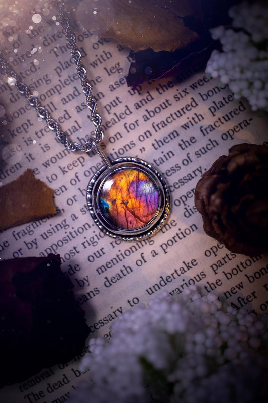 Beautiful and handcrafted, natural rainbow, pink, purple, and orange labradorite spectrolite pendant necklace. This beautiful pendant has been handmade using recycled fine and sterling silver. Featuring a round labradorite that is full of natural pinks, purples and orange hues. Around the crystal is a smooth inner bezel with gallery wire around as the outer bezel. This is the ideal piece of jewellery for a loved one or to treat yourself. Suitable for crystal and jewellery lovers. Gothic vibes.