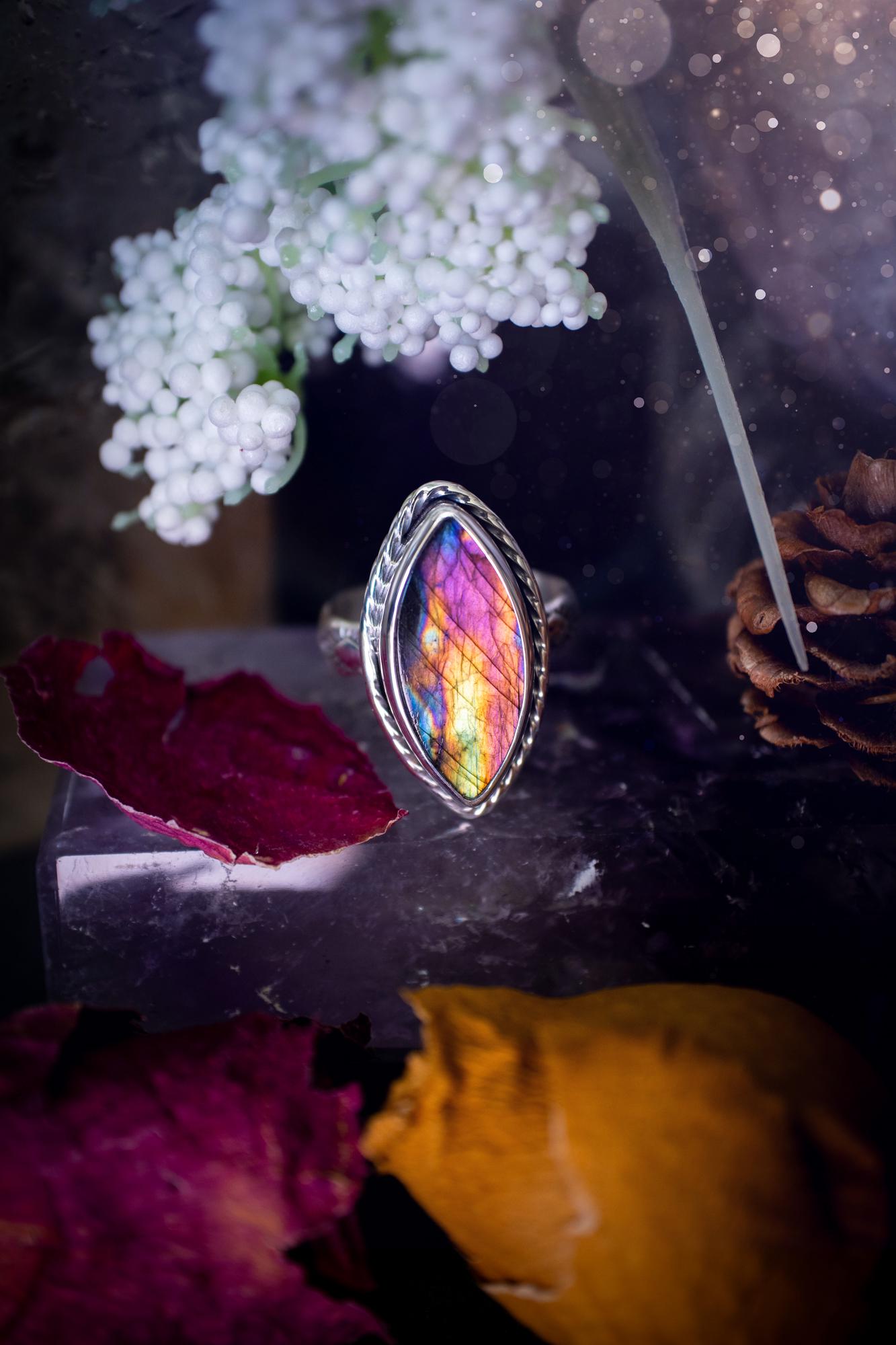 Handcrafted sterling silver statement ring featuring a stunning spectrolite labradorite crystal with vibrant flashes of purple, pink, and orange. This magical gemstone shimmers with an ethereal glow, making it a captivating piece for any jewellery collection. Ideal for crystal lovers, spiritual souls, and those drawn to unique, one-of-a-kind designs. A bold, mystical accessory perfect for expressing your inner light and energy. Gothic and handmade jewellery gifts, ideal for crystal lovers.