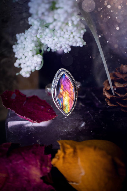 Handcrafted sterling silver statement ring featuring a stunning spectrolite labradorite crystal with vibrant flashes of purple, pink, and orange. This magical gemstone shimmers with an ethereal glow, making it a captivating piece for any jewellery collection. Ideal for crystal lovers, spiritual souls, and those drawn to unique, one-of-a-kind designs. A bold, mystical accessory perfect for expressing your inner light and energy. Gothic and handmade jewellery gifts, ideal for crystal lovers.