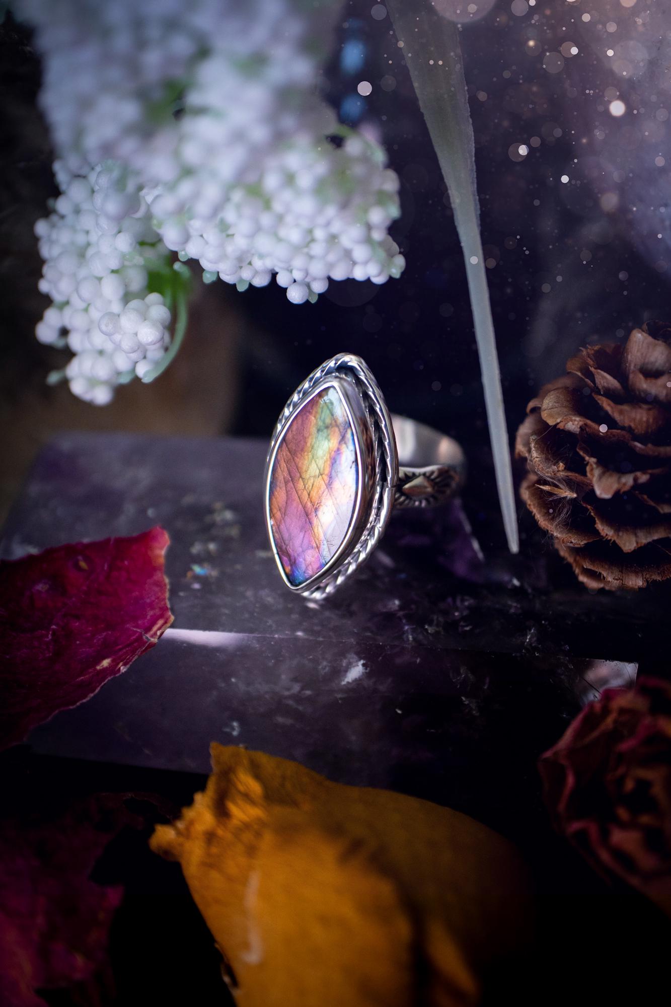 Handcrafted sterling silver statement ring featuring a stunning spectrolite labradorite crystal with vibrant flashes of purple, pink, and orange. This magical gemstone shimmers with an ethereal glow, making it a captivating piece for any jewellery collection. Ideal for crystal lovers, spiritual souls, and those drawn to unique, one-of-a-kind designs. A bold, mystical accessory perfect for expressing your inner light and energy. Gothic and handmade jewellery gifts, ideal for crystal lovers.
