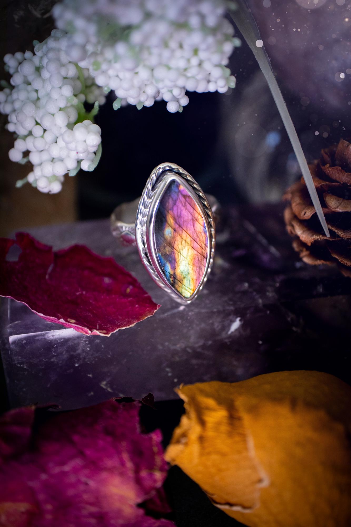 Handcrafted sterling silver statement ring featuring a stunning spectrolite labradorite crystal with vibrant flashes of purple, pink, and orange. This magical gemstone shimmers with an ethereal glow, making it a captivating piece for any jewellery collection. Ideal for crystal lovers, spiritual souls, and those drawn to unique, one-of-a-kind designs. A bold, mystical accessory perfect for expressing your inner light and energy. Gothic and handmade jewellery gifts, ideal for crystal lovers.
