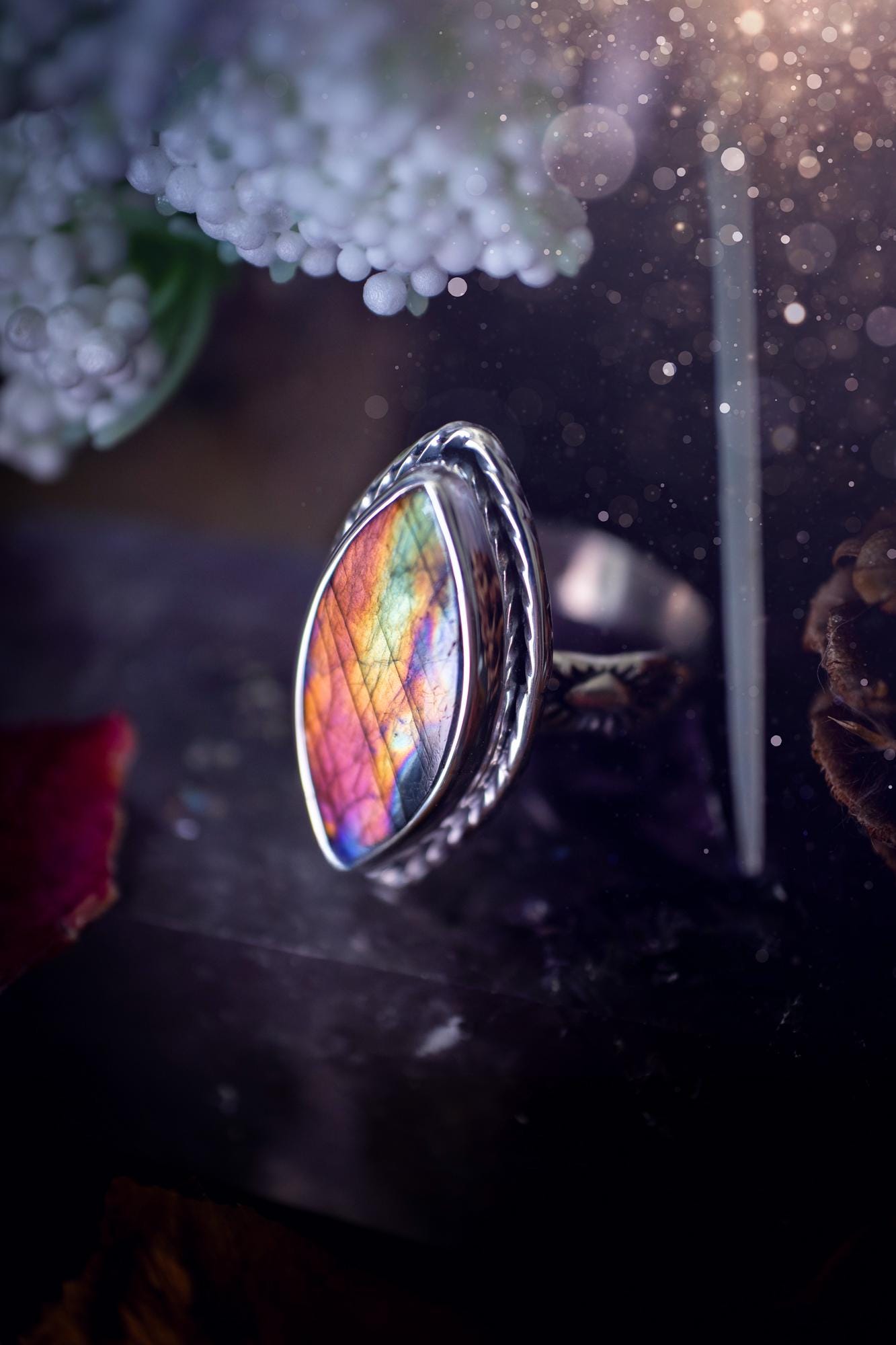 Handcrafted sterling silver statement ring featuring a stunning spectrolite labradorite crystal with vibrant flashes of purple, pink, and orange. This magical gemstone shimmers with an ethereal glow, making it a captivating piece for any jewellery collection. Ideal for crystal lovers, spiritual souls, and those drawn to unique, one-of-a-kind designs. A bold, mystical accessory perfect for expressing your inner light and energy. Gothic and handmade jewellery gifts, ideal for crystal lovers.