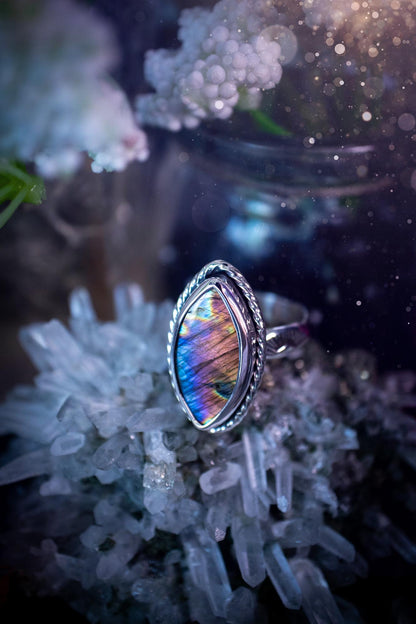 Handcrafted sterling silver statement ring featuring a stunning spectrolite labradorite crystal with vibrant flashes of purple, pink, and orange. This magical gemstone shimmers with an ethereal glow, making it a captivating piece for any jewellery collection. Ideal for crystal lovers, spiritual souls, and those drawn to unique, one-of-a-kind designs. A bold, mystical accessory perfect for expressing your inner light and energy. Gothic and handmade jewellery gifts, ideal for crystal lovers.