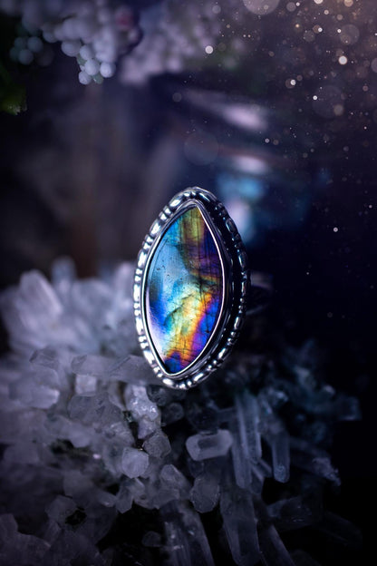 Handcrafted sterling silver statement ring featuring a stunning spectrolite labradorite crystal with vibrant flashes of purple, yellow, and blue. This magical gemstone shimmers with an ethereal glow, making it a captivating piece for any jewellery collection. Ideal for crystal lovers, spiritual souls, and those drawn to unique, one-of-a-kind designs. A bold, mystical accessory perfect for expressing your inner light and energy. Gothic and handmade jewellery gifts, ideal for crystal lovers.