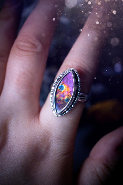 Handcrafted sterling silver statement ring featuring a stunning spectrolite labradorite crystal with vibrant flashes of purple, pink, and orange. This magical gemstone shimmers with an ethereal glow, making it a captivating piece for any jewellery collection. Ideal for crystal lovers, spiritual souls, and those drawn to unique, one-of-a-kind designs. A bold, mystical accessory perfect for expressing your inner light and energy. Gothic and handmade jewellery gifts, ideal for crystal lovers.