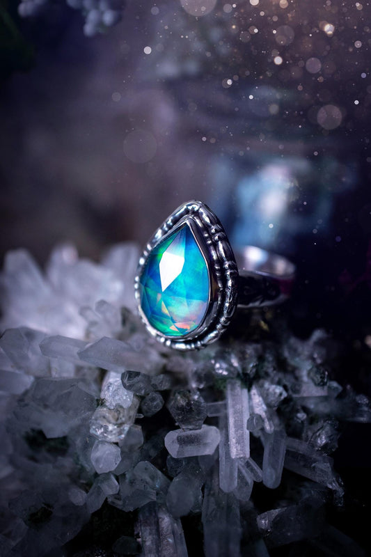 Beautiful and handmade, aurora synthetic opal, sterling silver bespoke ring. This ring has been handmade using a mix of recycled fine and sterling silver. Featuring a beautiful multi flash aurora opal that is full of blue, greens and pink hues depending on the angle. The stone is also rose cut and has a lovely sparkle. This piece is ideal for any jewellery or crystal lover and is full of witchy and hippy vibes! A beautiful mini statement ring for anyone&#39;s collection.