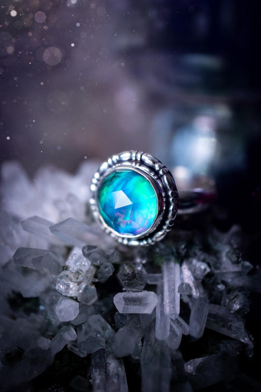 Beautiful and handmade, aurora synthetic opal, sterling silver bespoke ring. This ring has been handmade using a mix of recycled fine and sterling silver. Featuring a beautiful multi flash aurora opal that is full of blue, greens and pink hues depending on the angle. The stone is also rose cut and has a lovely sparkle. This piece is ideal for any jewellery or crystal lover and is full of witchy and hippy vibes! A beautiful mini statement ring for anyone&#39;s collection.