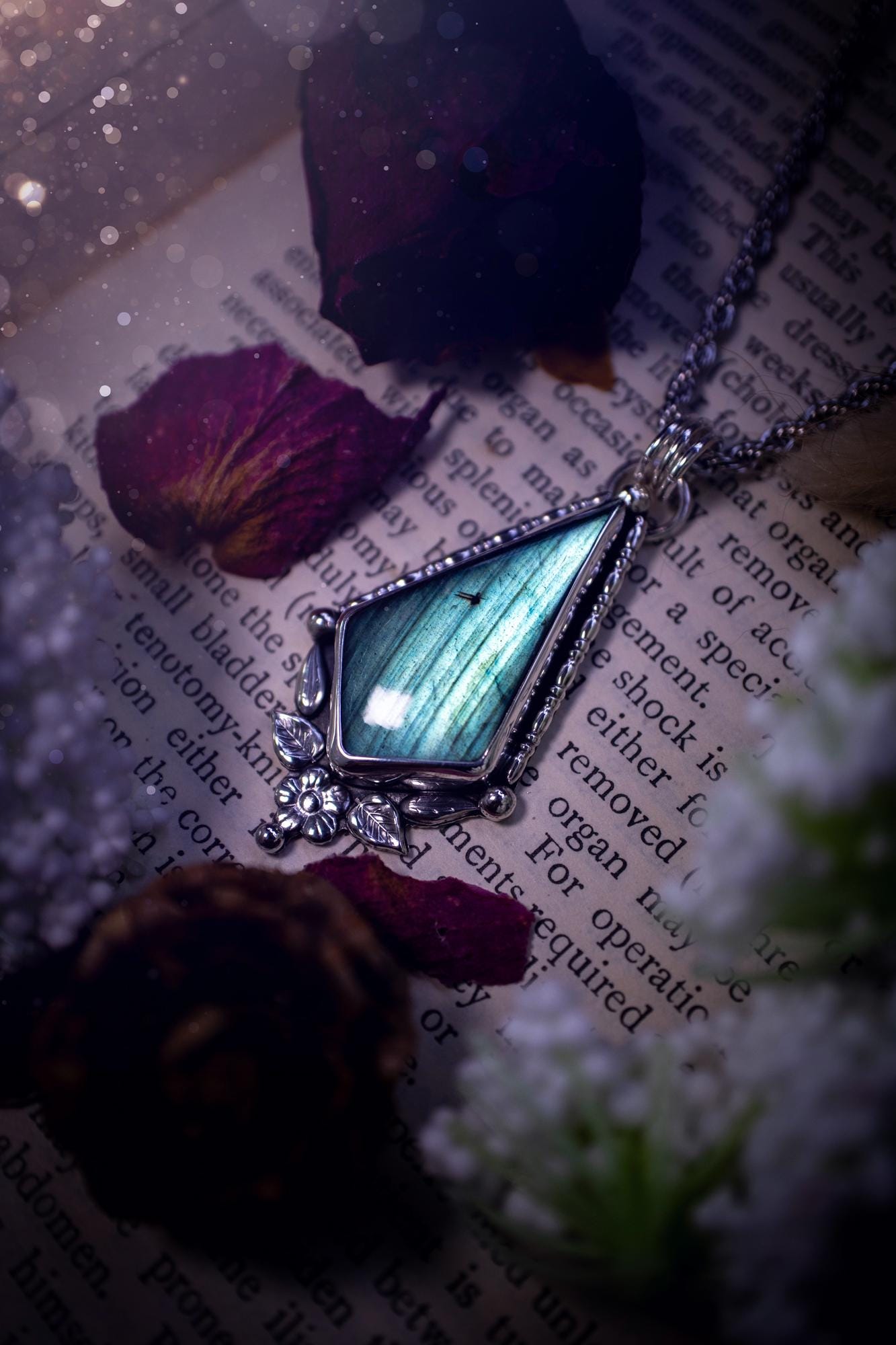 This stunning pendant necklace has been handcrafted using a mix of recycled fine and sterling silver. Featuring a beautiful and natural green and blue hued labradorite crystal that is full of flash! accompanying this magical crystal is a mix of fae inspired components such as little leaves, flower, silver balls and gothic gallery wire. A true bespoke piece with no other being the same! Ideal for any crystal and jewellery lover that loves a witchy and gothic vibe, along with the beauty of nature!
