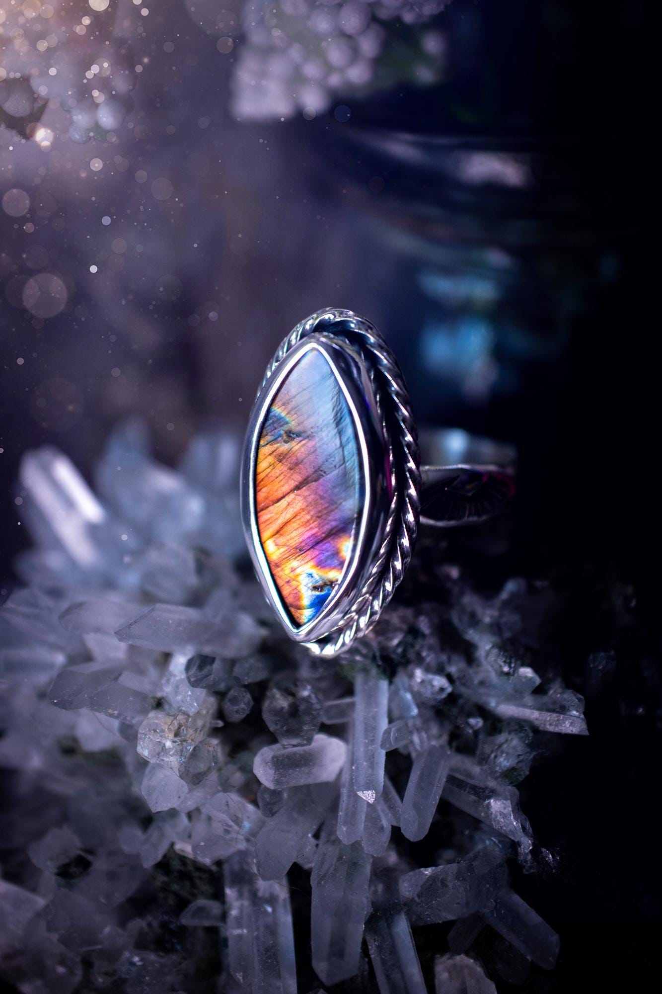 Handcrafted sterling silver statement ring featuring a stunning spectrolite labradorite crystal with vibrant flashes of purple, pink, and orange. This magical gemstone shimmers with an ethereal glow, making it a captivating piece for any jewellery collection. Ideal for crystal lovers, spiritual souls, and those drawn to unique, one-of-a-kind designs. A bold, mystical accessory perfect for expressing your inner light and energy. Gothic and handmade jewellery gifts, ideal for crystal lovers.