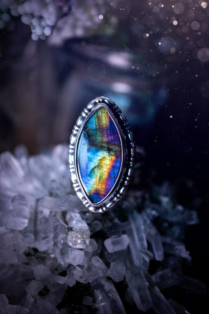 Handcrafted sterling silver statement ring featuring a stunning spectrolite labradorite crystal with vibrant flashes of purple, yellow, and blue. This magical gemstone shimmers with an ethereal glow, making it a captivating piece for any jewellery collection. Ideal for crystal lovers, spiritual souls, and those drawn to unique, one-of-a-kind designs. A bold, mystical accessory perfect for expressing your inner light and energy. Gothic and handmade jewellery gifts, ideal for crystal lovers.