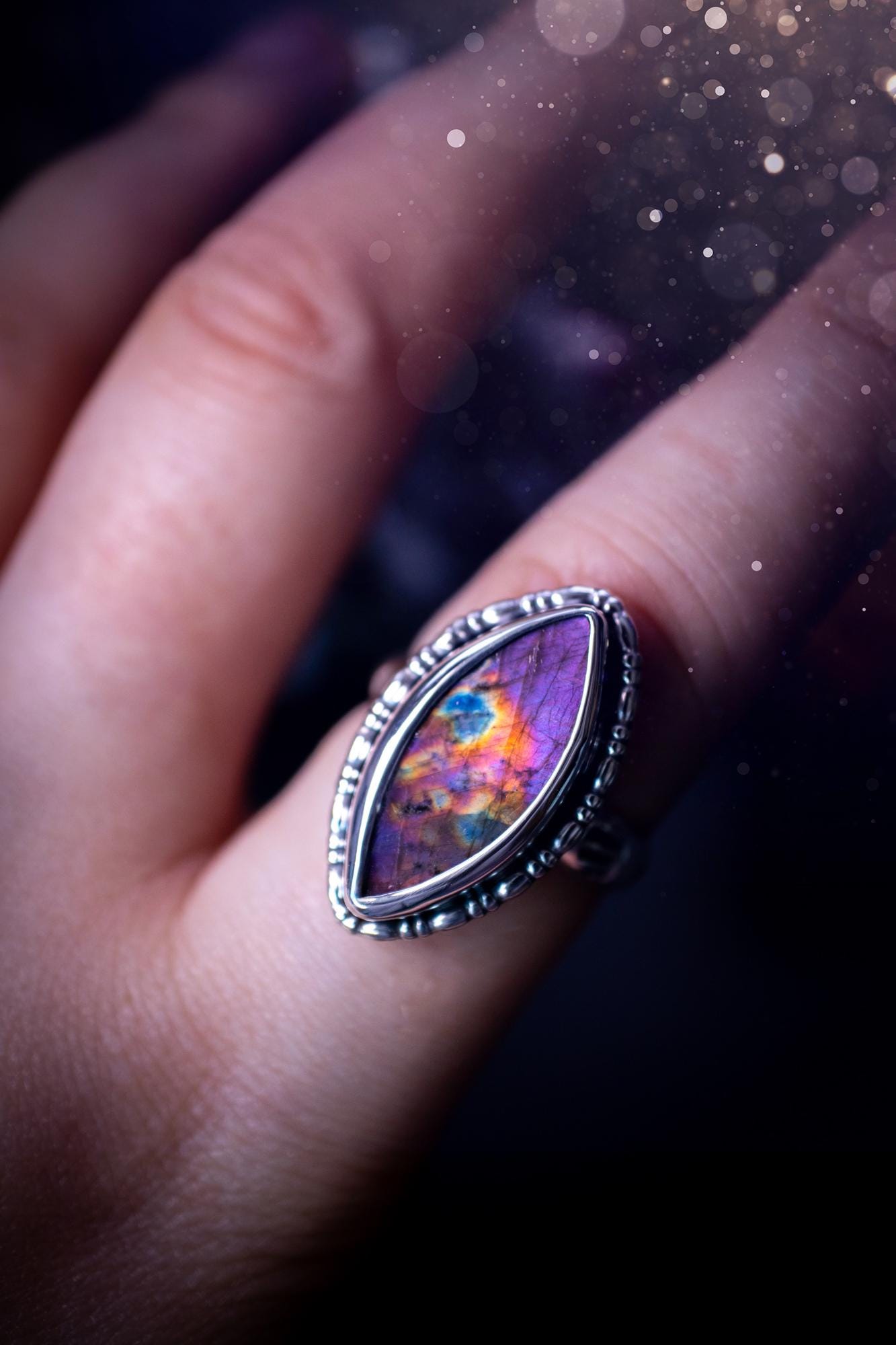 Handcrafted sterling silver statement ring featuring a stunning spectrolite labradorite crystal with vibrant flashes of purple, pink, and orange. This magical gemstone shimmers with an ethereal glow, making it a captivating piece for any jewellery collection. Ideal for crystal lovers, spiritual souls, and those drawn to unique, one-of-a-kind designs. A bold, mystical accessory perfect for expressing your inner light and energy. Gothic and handmade jewellery gifts, ideal for crystal lovers.