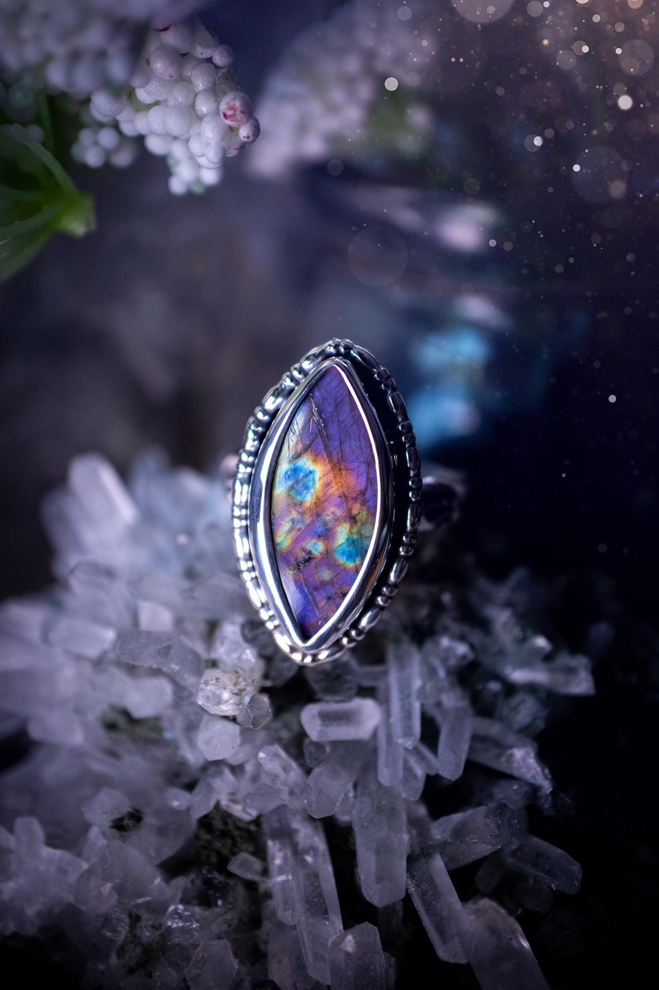 Handcrafted sterling silver statement ring featuring a stunning spectrolite labradorite crystal with vibrant flashes of purple, pink, and orange. This magical gemstone shimmers with an ethereal glow, making it a captivating piece for any jewellery collection. Ideal for crystal lovers, spiritual souls, and those drawn to unique, one-of-a-kind designs. A bold, mystical accessory perfect for expressing your inner light and energy. Gothic and handmade jewellery gifts, ideal for crystal lovers.