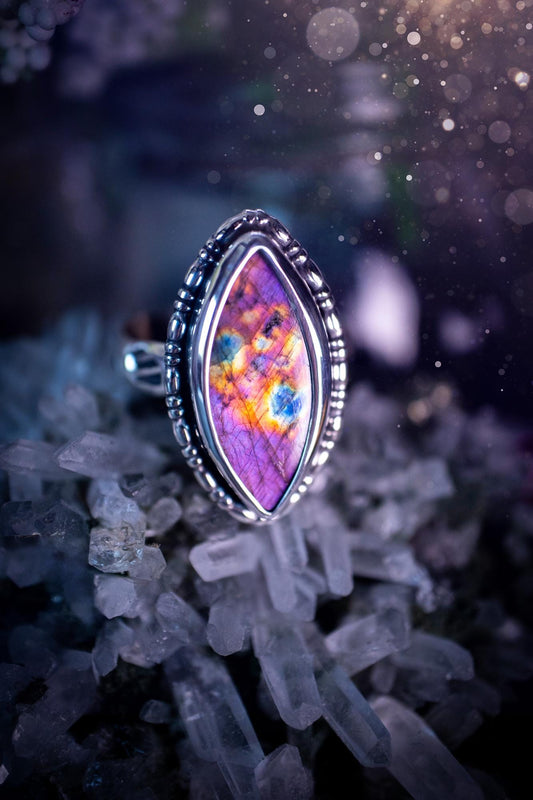 Handcrafted sterling silver statement ring featuring a stunning spectrolite labradorite crystal with vibrant flashes of purple, pink, and orange. This magical gemstone shimmers with an ethereal glow, making it a captivating piece for any jewellery collection. Ideal for crystal lovers, spiritual souls, and those drawn to unique, one-of-a-kind designs. A bold, mystical accessory perfect for expressing your inner light and energy. Gothic and handmade jewellery gifts, ideal for crystal lovers.