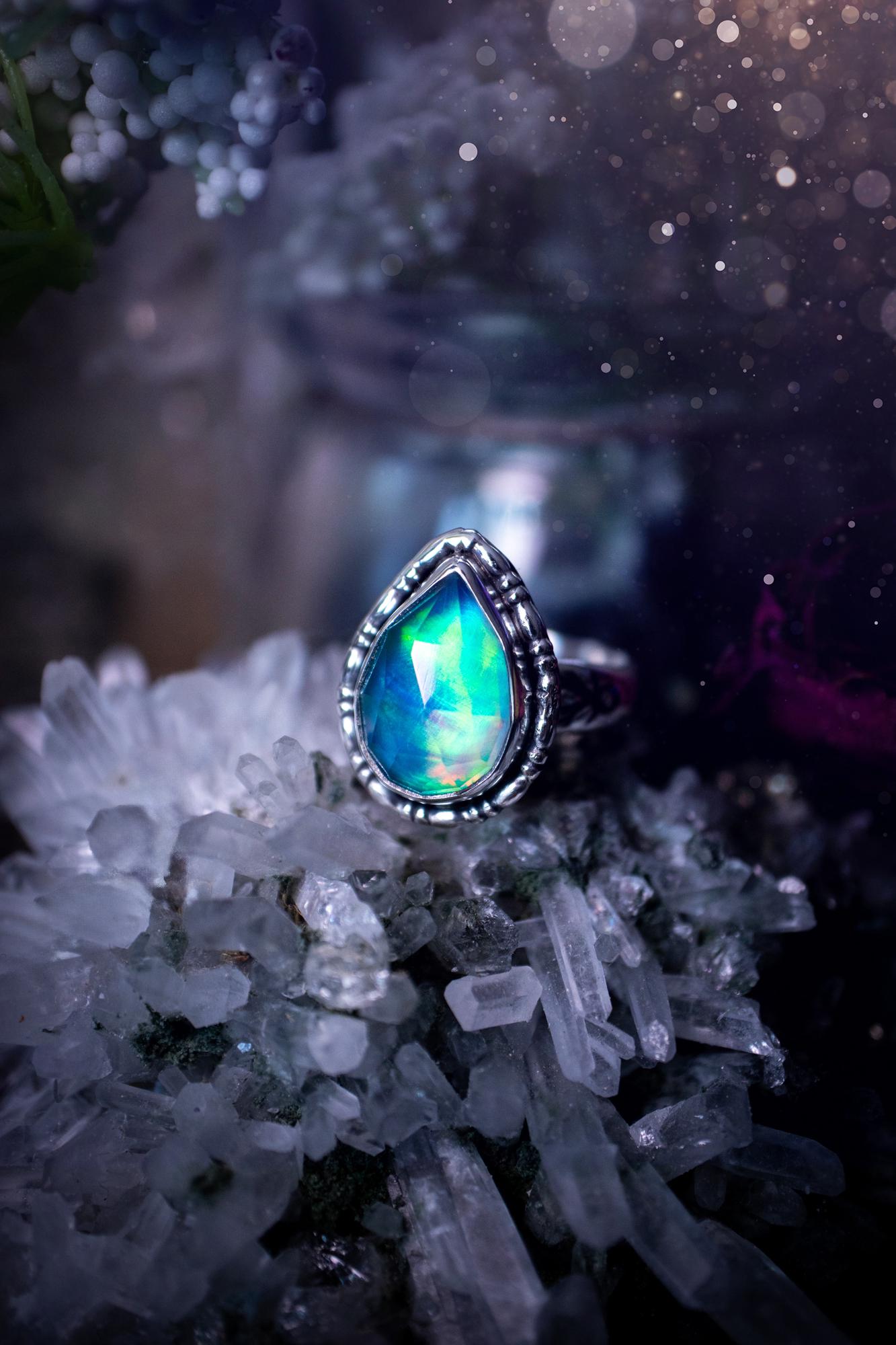 Beautiful and handmade, aurora synthetic opal, sterling silver bespoke ring. This ring has been handmade using a mix of recycled fine and sterling silver. Featuring a beautiful multi flash aurora opal that is full of blue, greens and pink hues depending on the angle. The stone is also rose cut and has a lovely sparkle. This piece is ideal for any jewellery or crystal lover and is full of witchy and hippy vibes! A beautiful mini statement ring for anyone&#39;s collection.