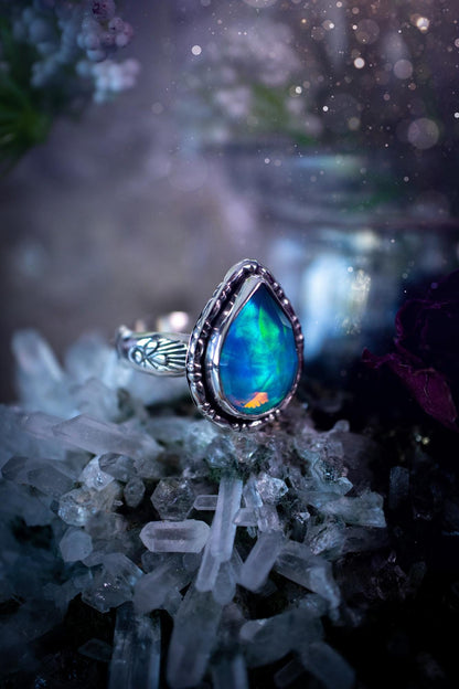 Beautiful and handmade, aurora synthetic opal, sterling silver bespoke ring. This ring has been handmade using a mix of recycled fine and sterling silver. Featuring a beautiful multi flash aurora opal that is full of blue, greens and pink hues depending on the angle. The stone is also rose cut and has a lovely sparkle. This piece is ideal for any jewellery or crystal lover and is full of witchy and hippy vibes! A beautiful mini statement ring for anyone&#39;s collection.