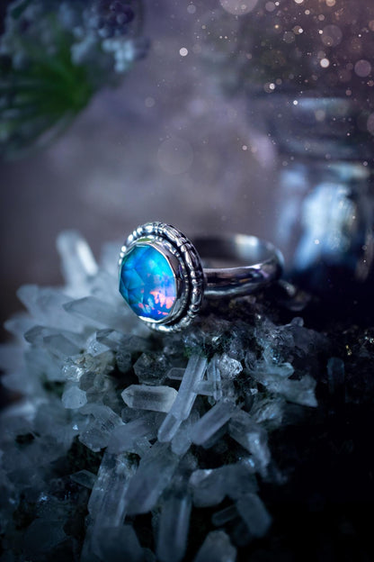 Beautiful and handmade, aurora synthetic opal, sterling silver bespoke ring. This ring has been handmade using a mix of recycled fine and sterling silver. Featuring a beautiful multi flash aurora opal that is full of blue, greens and pink hues depending on the angle. The stone is also rose cut and has a lovely sparkle. This piece is ideal for any jewellery or crystal lover and is full of witchy and hippy vibes! A beautiful mini statement ring for anyone&#39;s collection.