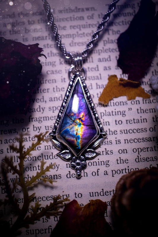 This stunning pendant necklace has been handcrafted using a mix of recycled fine and sterling silver. Featuring a beautiful and natural purple and pink hued labradorite crystal that is full of flash! accompanying this magical crystal is a mix of fae inspired components such as little leaves, flower, silver balls and gothic gallery wire. A true bespoke piece with no other being the same! Ideal for any crystal and jewellery lover that loves a witchy and gothic vibe, along with the beauty of nature