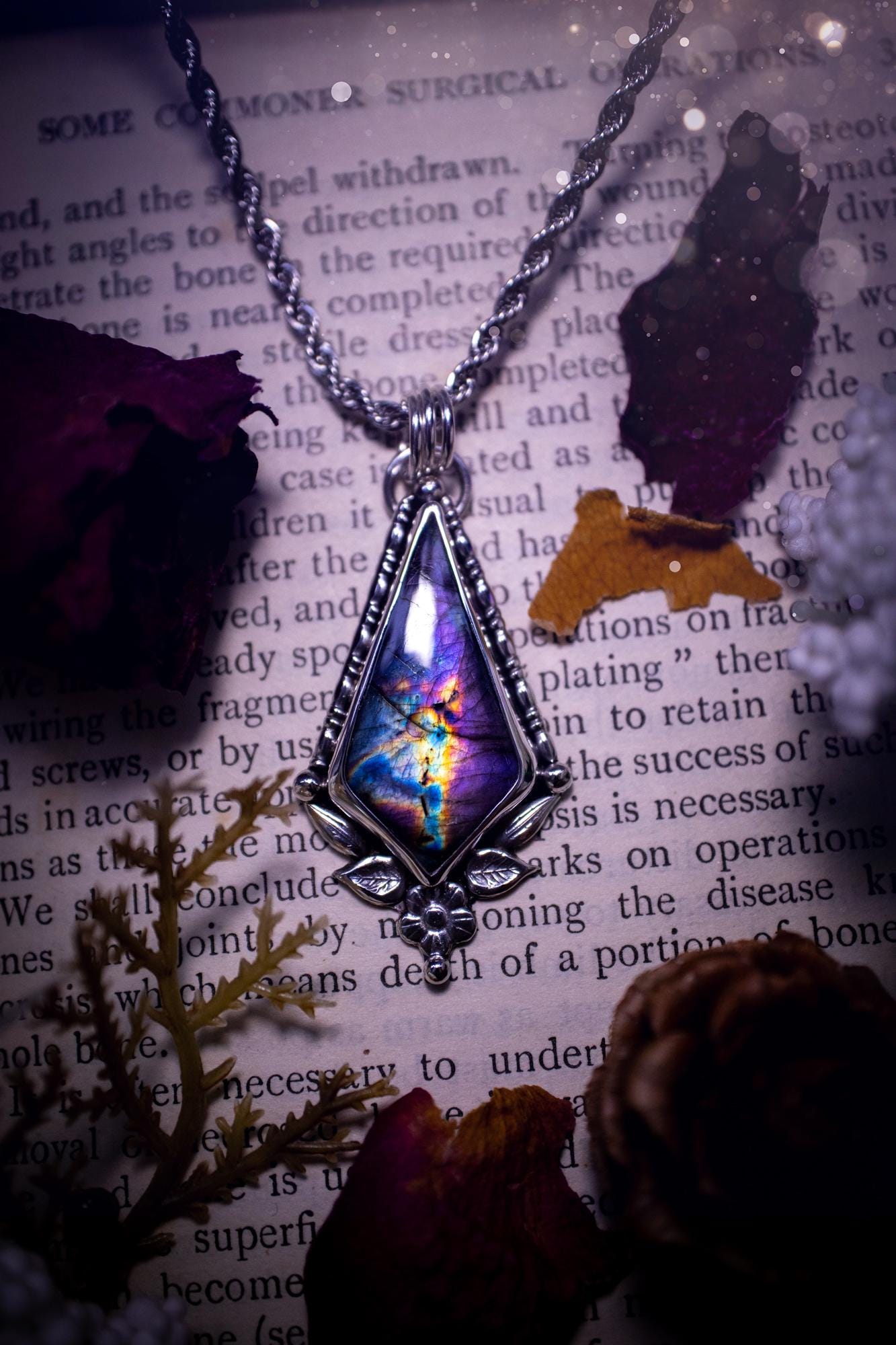 This stunning pendant necklace has been handcrafted using a mix of recycled fine and sterling silver. Featuring a beautiful and natural purple and pink hued labradorite crystal that is full of flash! accompanying this magical crystal is a mix of fae inspired components such as little leaves, flower, silver balls and gothic gallery wire. A true bespoke piece with no other being the same! Ideal for any crystal and jewellery lover that loves a witchy and gothic vibe, along with the beauty of nature