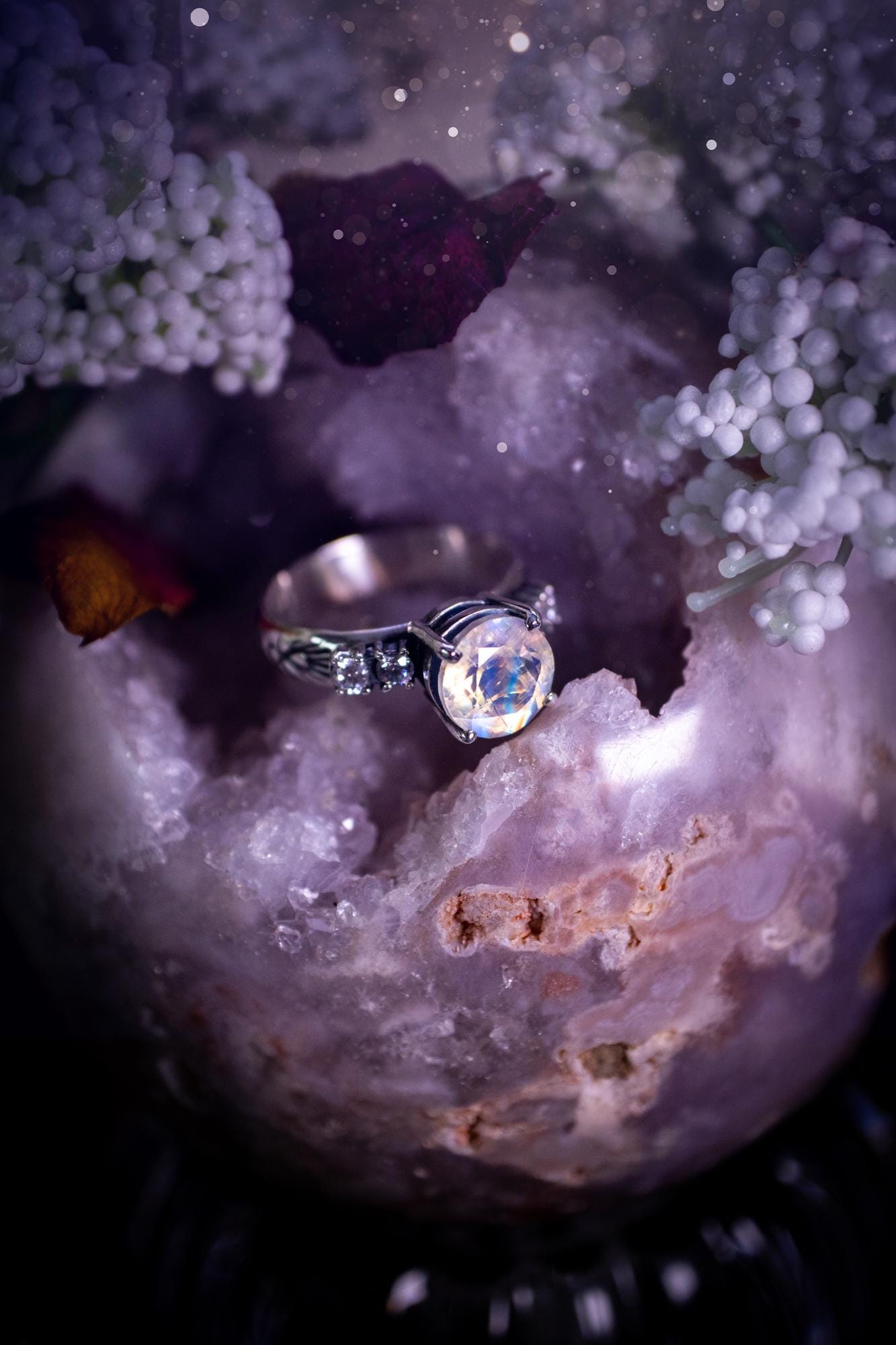 Beautifully handmade, and bespoke, natural rainbow moonstone statement ring. This one of a kind ring has been handmade using a mix of fine and sterling silver. Featuring a beautiful, flashy round, natural rainbow moonstone crystal that has stunning hues of blue, along with cubic zirconia to the sides of the crystal. The ring band is stamped with unique detailing. The ideal treat and gift for anyone who is a lover of crystals and jewellery. This ring is full of gothic and witchy vibes!