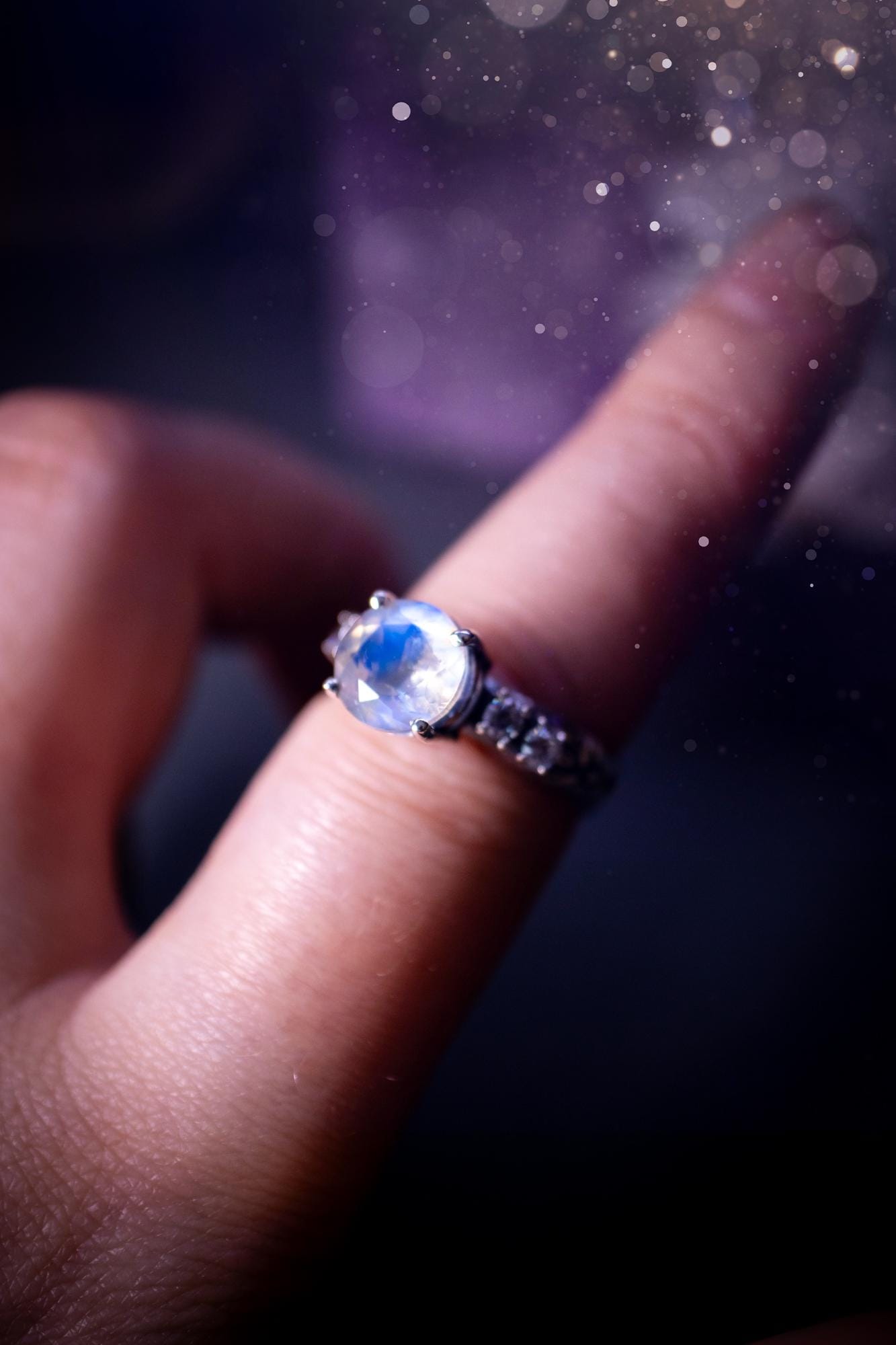 Beautifully handmade, and bespoke, natural rainbow moonstone statement ring. This one of a kind ring has been handmade using a mix of fine and sterling silver. Featuring a beautiful, flashy round, natural rainbow moonstone crystal that has stunning hues of blue, along with cubic zirconia to the sides of the crystal. The ring band is stamped with unique detailing. The ideal treat and gift for anyone who is a lover of crystals and jewellery. This ring is full of gothic and witchy vibes!