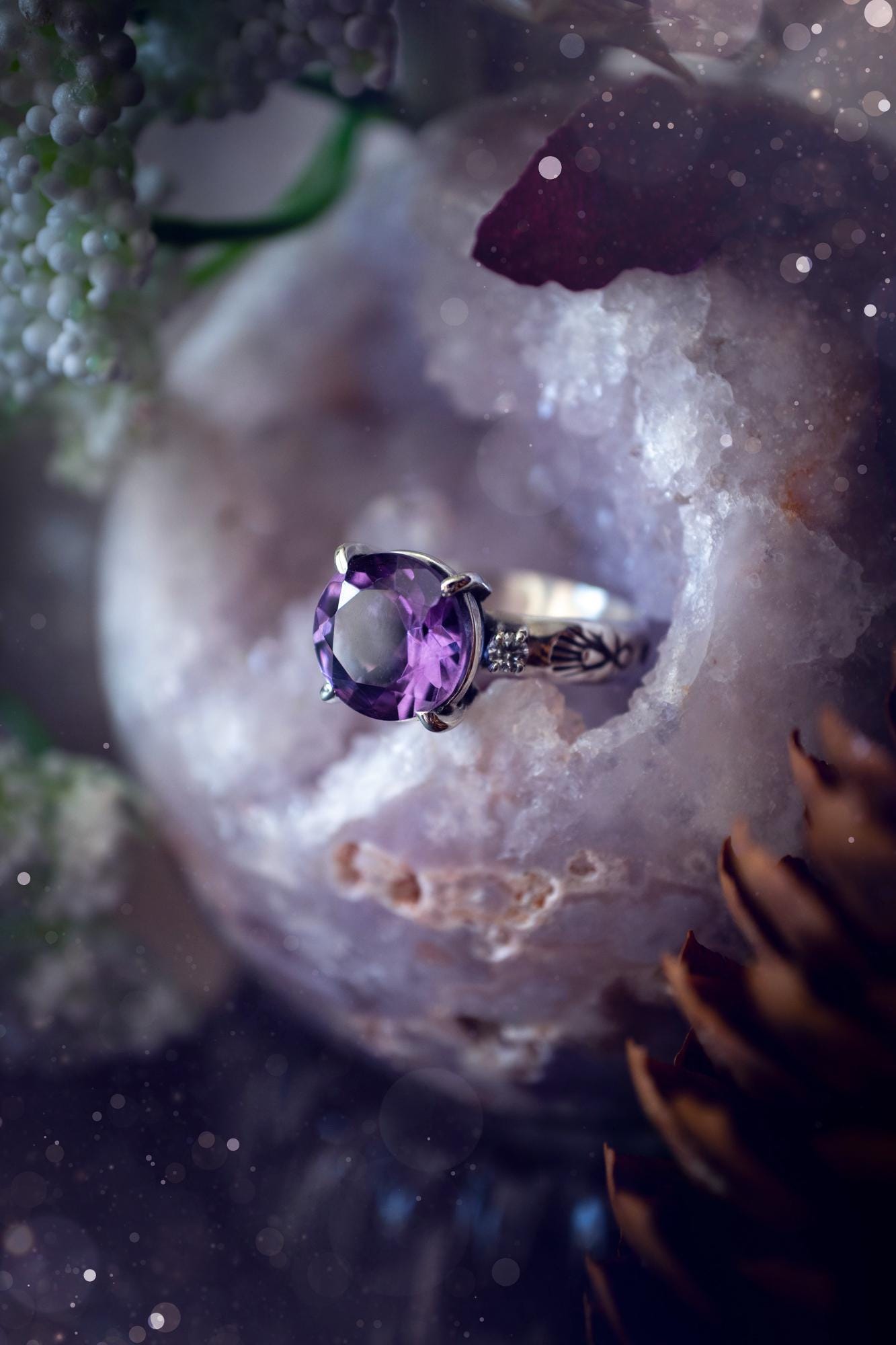Beautifully handmade, and bespoke, natural amethyst crystal statement ring. This one of a kind ring has been handmade using a mix of fine and sterling silver. Featuring a beautiful, sparkly, round, natural amethyst crystal that has stunning hues of purple, along with cubic zirconia to the sides of the crystal. The ring band is stamped with unique detailing. The ideal treat and gift for anyone who is a lover of crystals and jewellery. This ring is full of gothic and witchy vibes! engagement ring