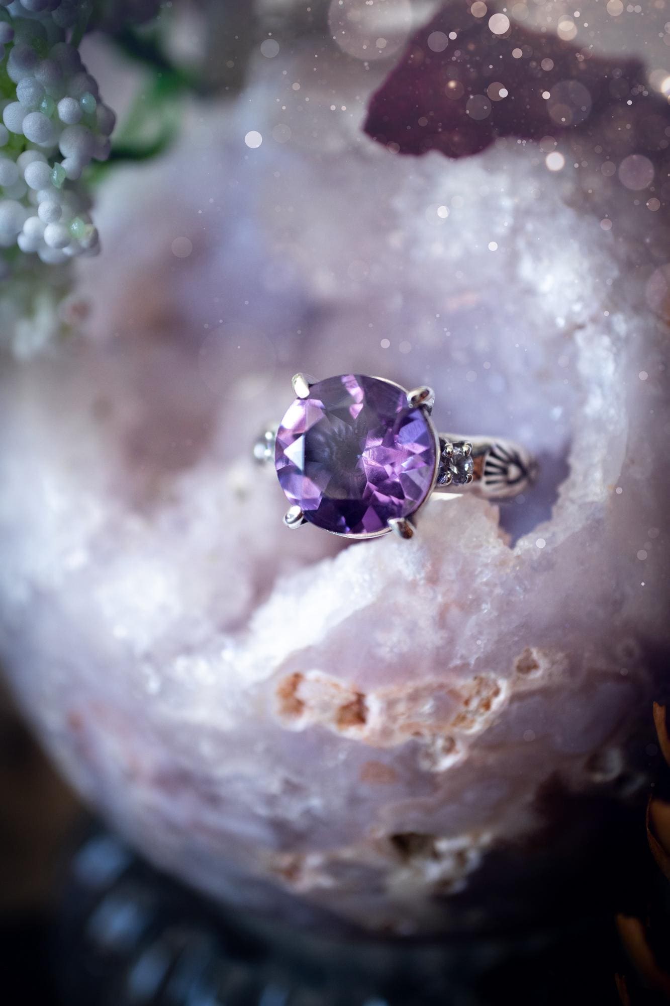Beautifully handmade, and bespoke, natural amethyst crystal statement ring. This one of a kind ring has been handmade using a mix of fine and sterling silver. Featuring a beautiful, sparkly, round, natural amethyst crystal that has stunning hues of purple, along with cubic zirconia to the sides of the crystal. The ring band is stamped with unique detailing. The ideal treat and gift for anyone who is a lover of crystals and jewellery. This ring is full of gothic and witchy vibes! engagement ring