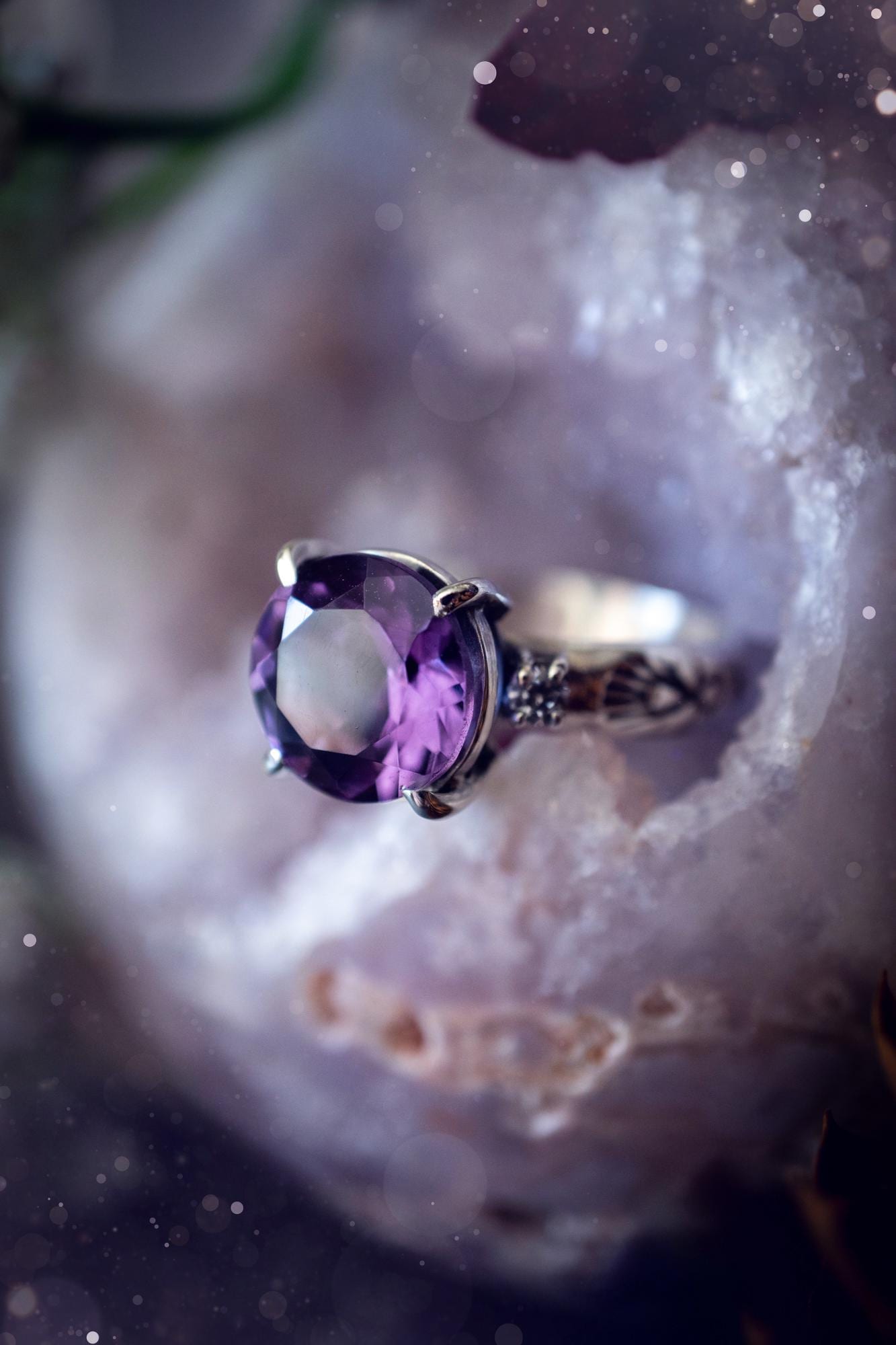 Beautifully handmade, and bespoke, natural amethyst crystal statement ring. This one of a kind ring has been handmade using a mix of fine and sterling silver. Featuring a beautiful, sparkly, round, natural amethyst crystal that has stunning hues of purple, along with cubic zirconia to the sides of the crystal. The ring band is stamped with unique detailing. The ideal treat and gift for anyone who is a lover of crystals and jewellery. This ring is full of gothic and witchy vibes! engagement ring