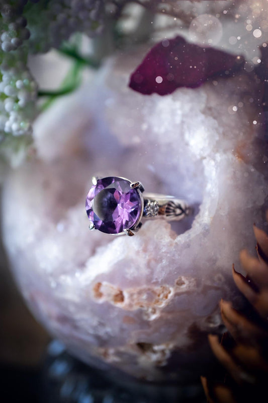 Beautifully handmade, and bespoke, natural amethyst crystal statement ring. This one of a kind ring has been handmade using a mix of fine and sterling silver. Featuring a beautiful, sparkly, round, natural amethyst crystal that has stunning hues of purple, along with cubic zirconia to the sides of the crystal. The ring band is stamped with unique detailing. The ideal treat and gift for anyone who is a lover of crystals and jewellery. This ring is full of gothic and witchy vibes! engagement ring