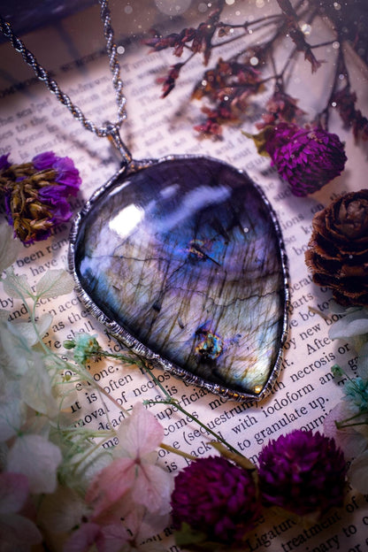 A very unique and one of a kind, soft soldered, labradorite, statement pendant necklace. The labradorite on this pendant is very unique as it is full of silver, purples and blues, with little rainbow clusters. It also has two separate flashing areas on the crystal. Large and beautiful! Handmade using the soft solder method also known as the tiffany technique! This piece of jewellery is a must have for any crystal and jewellery lover, it is full of gothic and witchy vibes! Jewellery for the soul