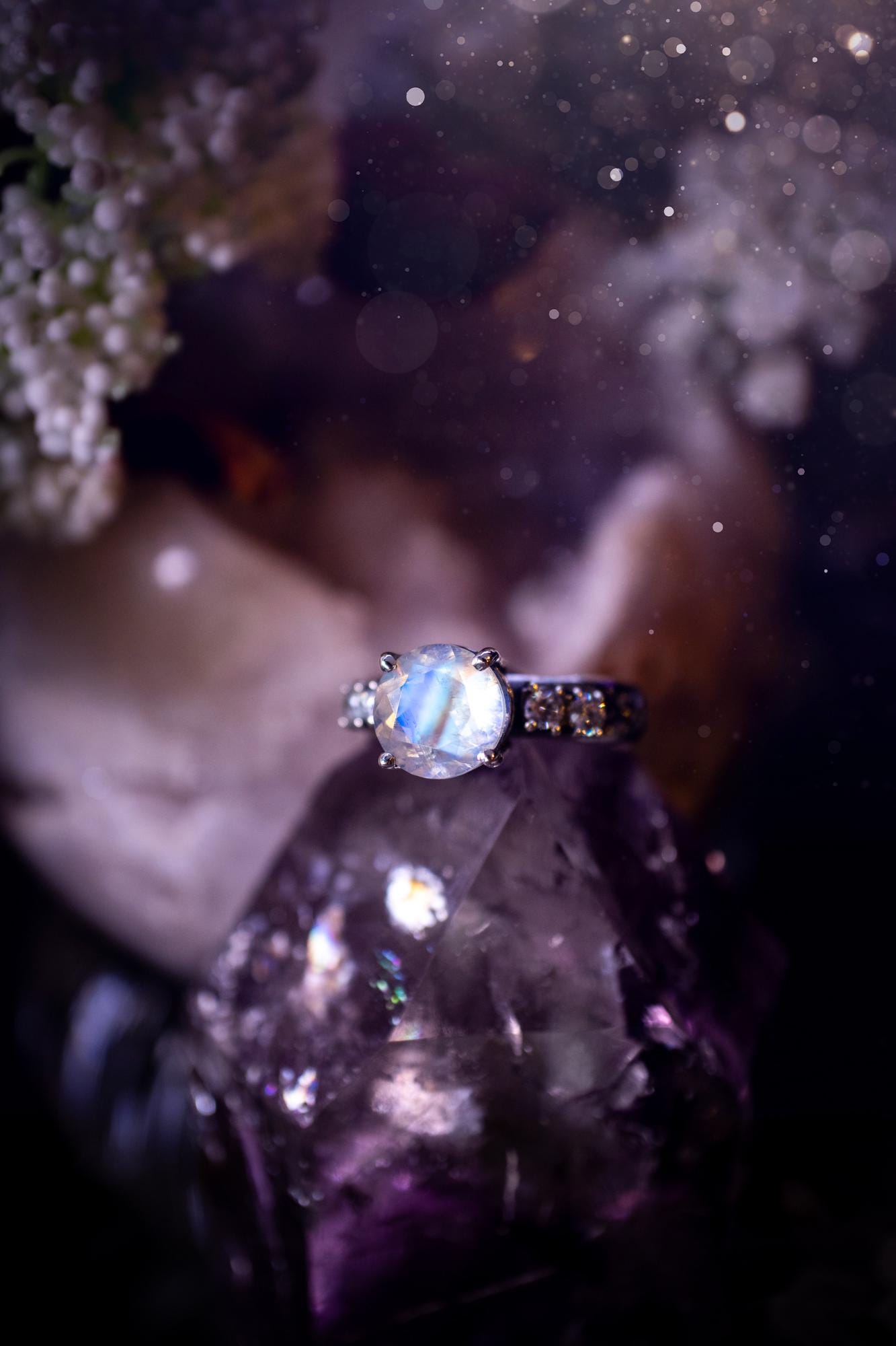 Beautifully handmade, and bespoke, natural rainbow moonstone statement ring. This one of a kind ring has been handmade using a mix of fine and sterling silver. Featuring a beautiful, flashy round, natural rainbow moonstone crystal that has stunning hues of blue, along with cubic zirconia to the sides of the crystal. The ring band is stamped with unique detailing. The ideal treat and gift for anyone who is a lover of crystals and jewellery. This ring is full of gothic and witchy vibes!