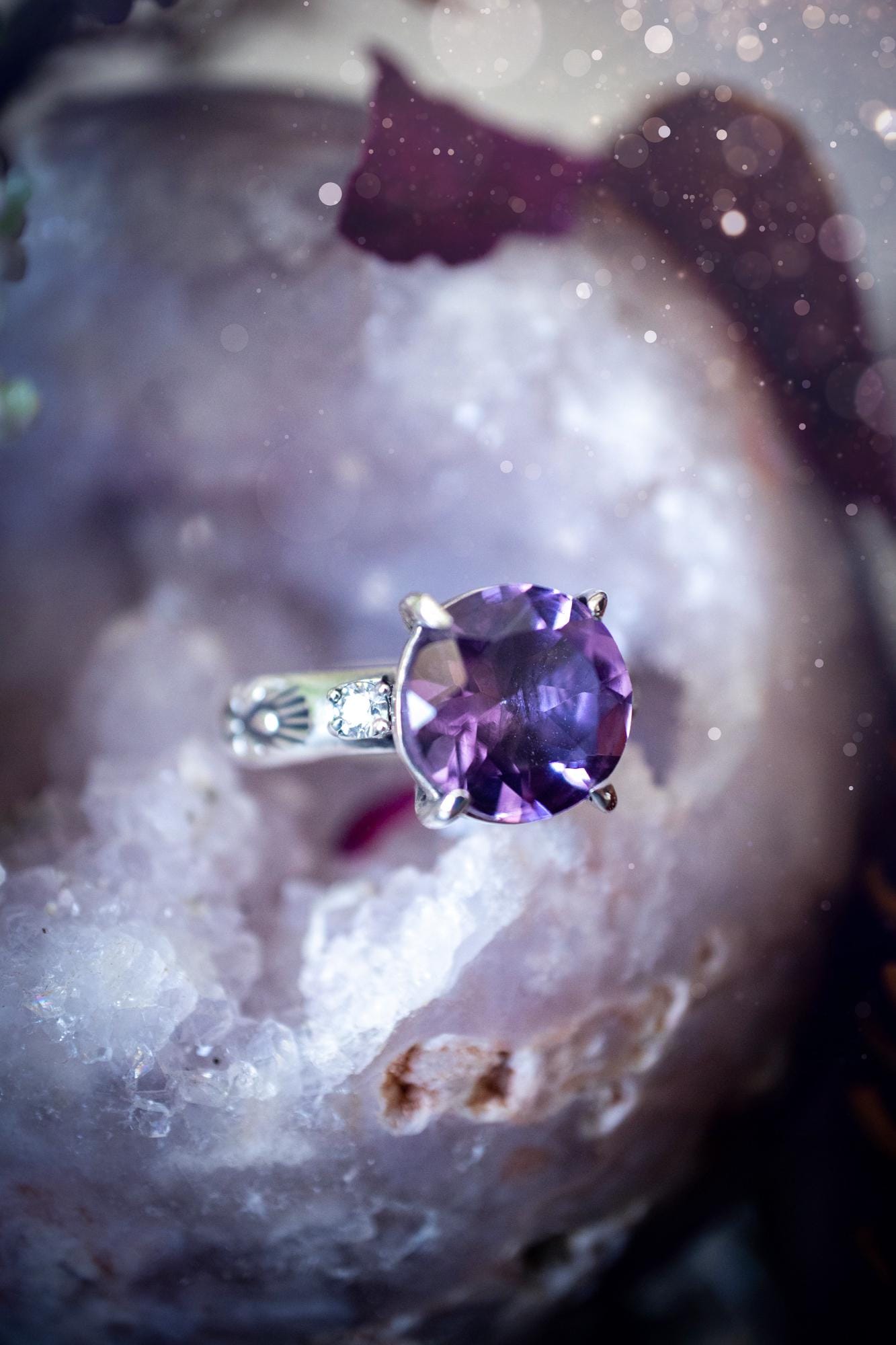 Beautifully handmade, and bespoke, natural amethyst crystal statement ring. This one of a kind ring has been handmade using a mix of fine and sterling silver. Featuring a beautiful, sparkly, round, natural amethyst crystal that has stunning hues of purple, along with cubic zirconia to the sides of the crystal. The ring band is stamped with unique detailing. The ideal treat and gift for anyone who is a lover of crystals and jewellery. This ring is full of gothic and witchy vibes! engagement ring
