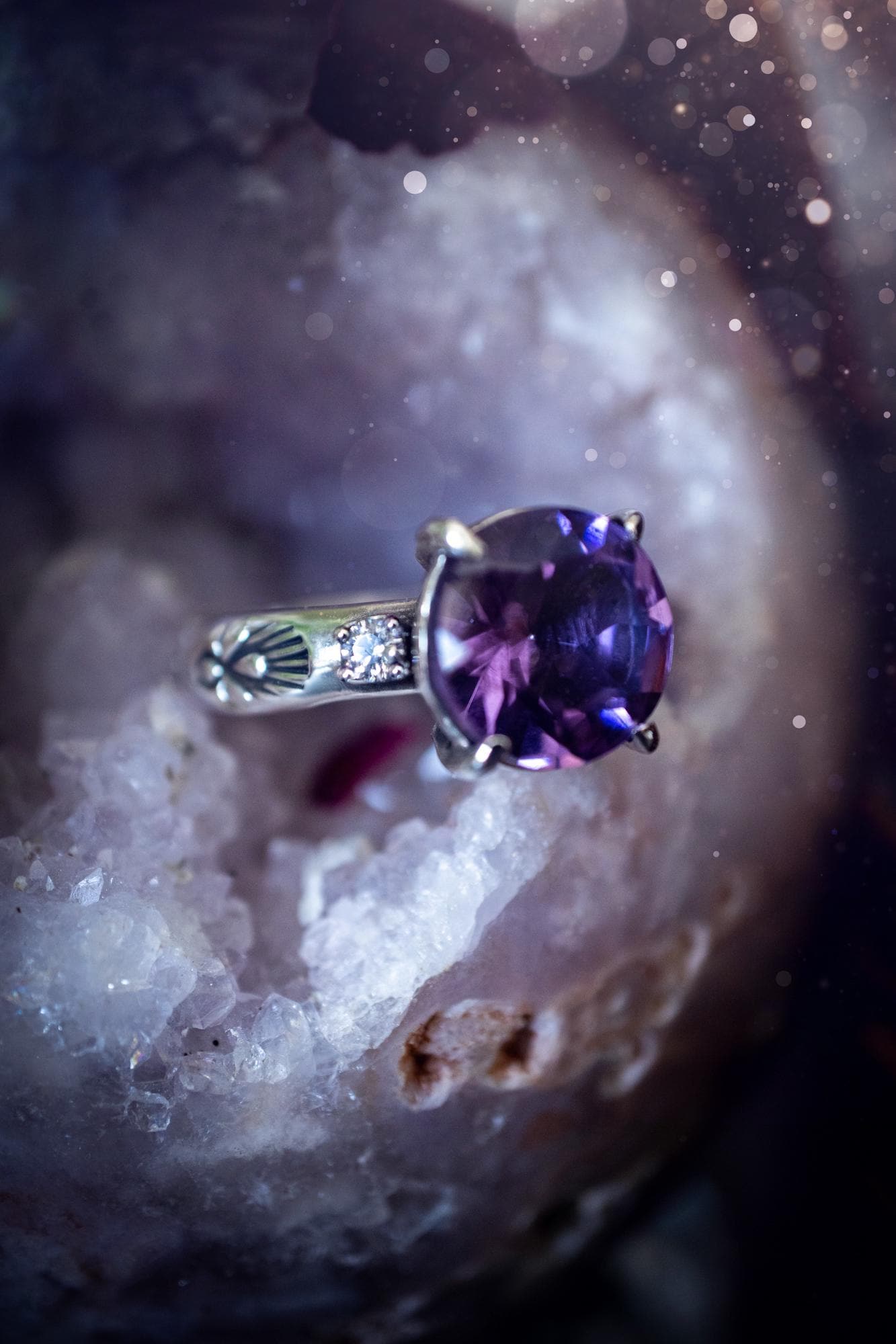 Beautifully handmade, and bespoke, natural amethyst crystal statement ring. This one of a kind ring has been handmade using a mix of fine and sterling silver. Featuring a beautiful, sparkly, round, natural amethyst crystal that has stunning hues of purple, along with cubic zirconia to the sides of the crystal. The ring band is stamped with unique detailing. The ideal treat and gift for anyone who is a lover of crystals and jewellery. This ring is full of gothic and witchy vibes! engagement ring