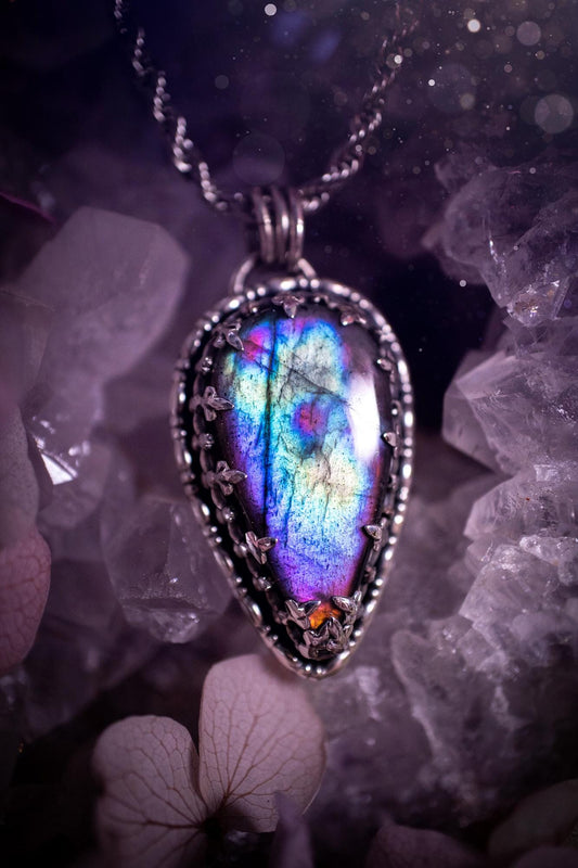 Beautifully handcrafted, rainbow labradorite crystal pendant necklace. This beautiful pendant has been crafted out of sterling and fine silver and features a gothic bezel around the labradorite crystal. The labradorite in this piece is full of beautiful colours, purple, greens, blues with a bit of orange! A really stunning crystal. This jewellery piece would be ideal for anyone who is a fan of jewellery and crystals, and would make the ideal gift. Full of witchy and gothic vibes!