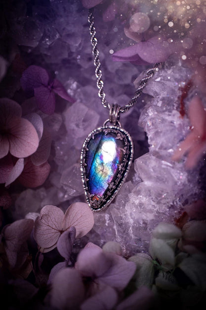 Beautifully handcrafted, rainbow labradorite crystal pendant necklace. This beautiful pendant has been crafted out of sterling and fine silver and features a gothic bezel around the labradorite crystal. The labradorite in this piece is full of beautiful colours, purple, greens, blues with a bit of orange! A really stunning crystal. This jewellery piece would be ideal for anyone who is a fan of jewellery and crystals, and would make the ideal gift. Full of witchy and gothic vibes!