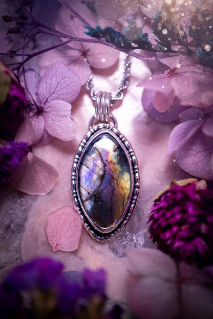 Beautifully handcrafted, rainbow labradorite crystal pendant necklace. This beautiful pendant has been crafted out of sterling and fine silver and features gothic bezel wire around the labradorite crystal. The labradorite in this piece is full of beautiful colours, purple, silvers, blues with a bit of orange! A really stunning crystal. This jewellery piece would be ideal for anyone who is a fan of jewellery and crystals, and would make the ideal gift. Full of witchy and gothic vibes!