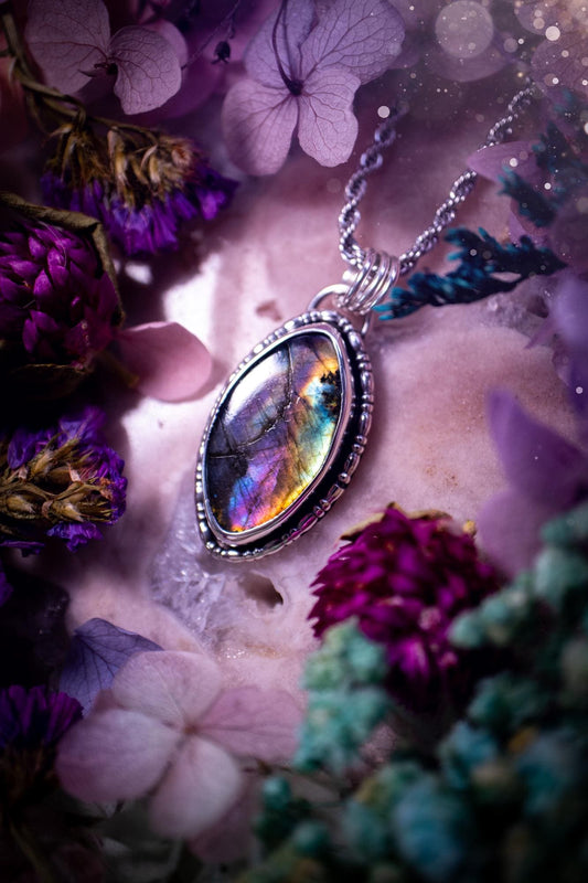 Beautifully handcrafted, rainbow labradorite crystal pendant necklace. This beautiful pendant has been crafted out of sterling and fine silver and features gothic bezel wire around the labradorite crystal. The labradorite in this piece is full of beautiful colours, purple, silvers, blues with a bit of orange! A really stunning crystal. This jewellery piece would be ideal for anyone who is a fan of jewellery and crystals, and would make the ideal gift. Full of witchy and gothic vibes!