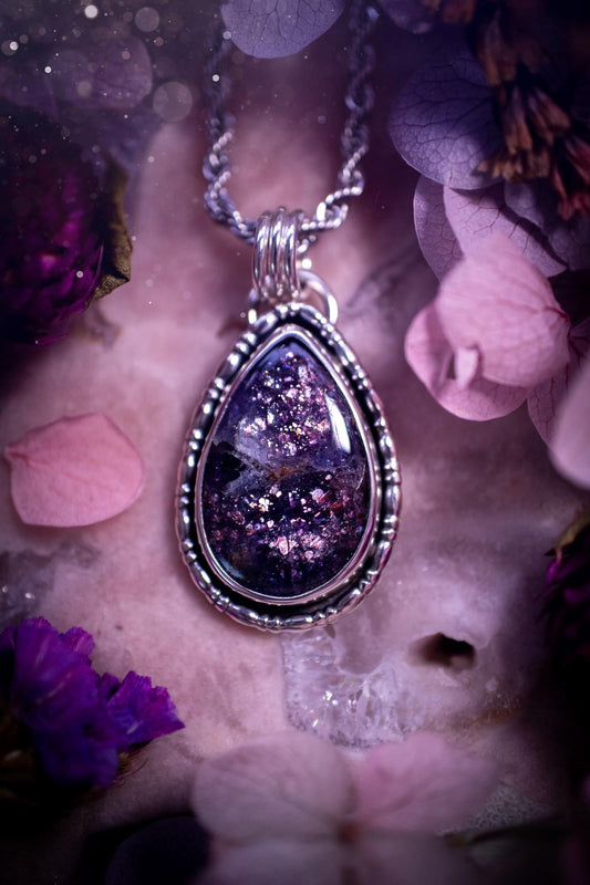 Stunning and handcrafted, natural Iolite sunstone, crystal pendant necklace. This beautiful pendant features a very sparkly iolite sunstone crystal that looks just like the galaxy, full of sparkle and pink shimmer. Made from a mix of sterling and fine silver, this piece is full of gothic vibes and has a gothic gallery wire around the crystal. Small and dainty. This piece would be suitable for gifting to jewellery and crystal lovers. Very witchy, gothic and hippy!