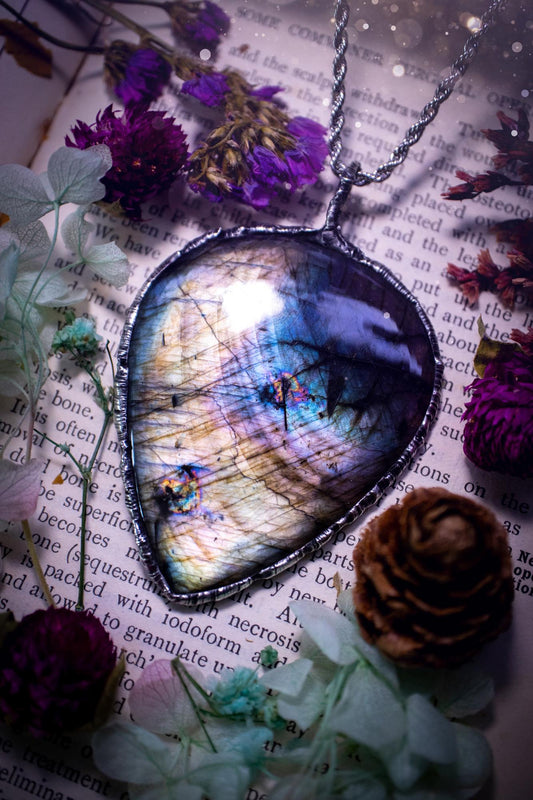 A very unique and one of a kind, soft soldered, labradorite, statement pendant necklace. The labradorite on this pendant is very unique as it is full of silver, purples and blues, with little rainbow clusters. It also has two separate flashing areas on the crystal. Large and beautiful! Handmade using the soft solder method also known as the tiffany technique! This piece of jewellery is a must have for any crystal and jewellery lover, it is full of gothic and witchy vibes! Jewellery for the soul