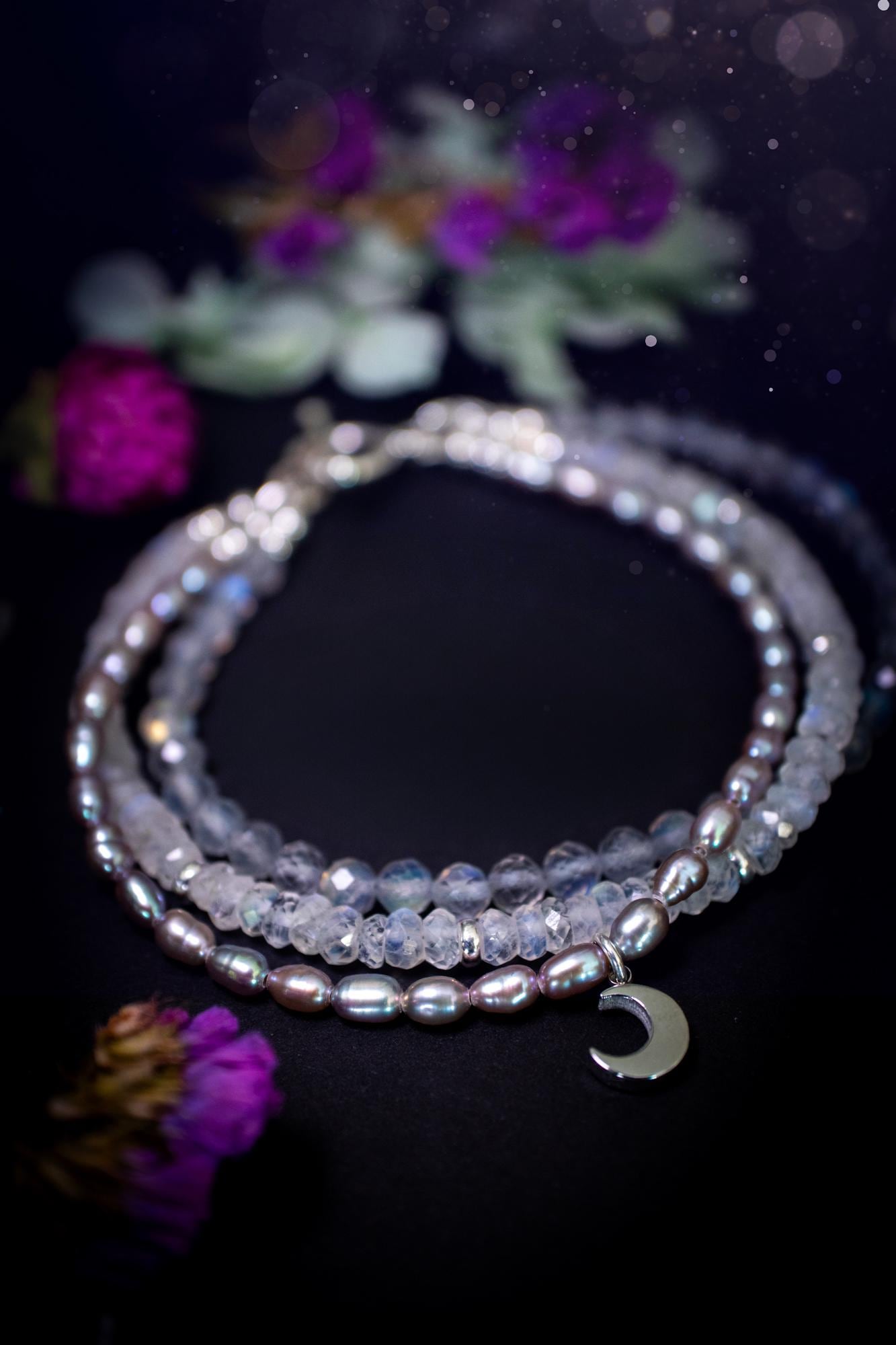 Stunning and handcrafted, triple crystal beaded bracelet. This beautiful bracelet consists of three bracelets in one all held together with a sterling silver t-bar toggle clasp. Featuring stunning flashy rainbow moonstone, light coloured labradorite, and grey to purple fresh water pearls. The findings on this bracelet are sterling silver, with a stainless steel moon charm. This piece is totally bespoke and full of celestial vibes. Ideal for any crystal and jewellery lover. Witchy and gothic